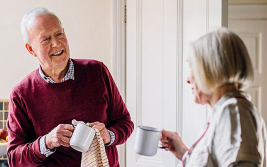 Senior couple, cleaning up their coffee mugs, chatting